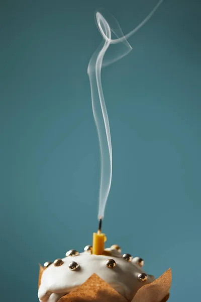 Вибірковий фокус прикрашеного великоднього торта зі свічкою і димом на бірюзовому — стокове фото