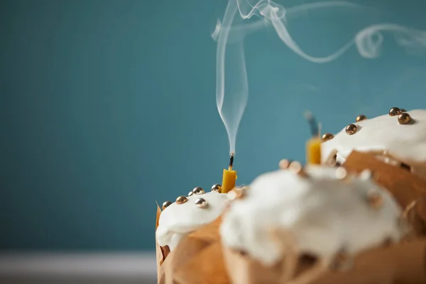 Selective focus of decorated easter cakes with candles and smoke on turquoise — Stock Photo