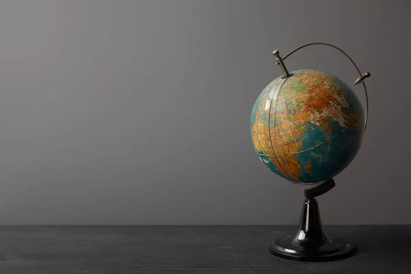 Viejo globo en la superficie de textura oscura en gris - foto de stock