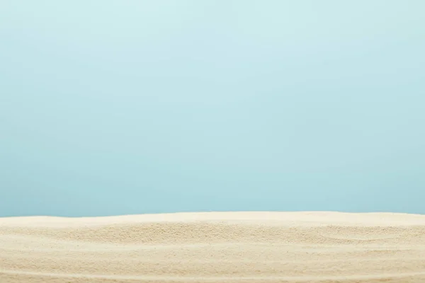 Selective focus of golden and textured sandy beach isolated on blue — Stock Photo