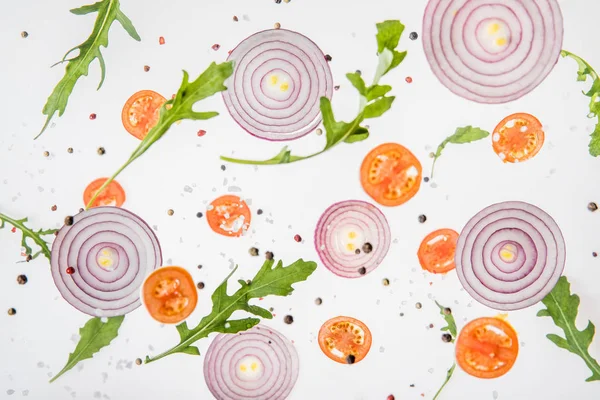 Fond de tomates tranchées, oignons rouges, feuilles de roquette verte et épices — Photo de stock