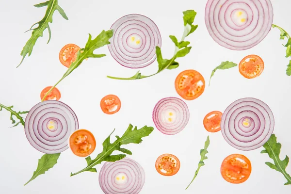 Background with sliced red tomatoes, red onions and green arugula leaves — Stock Photo
