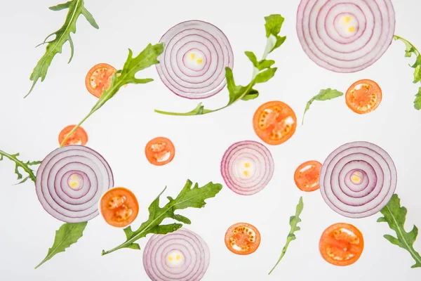 Fond de tomates rouges tranchées, oignons rouges et feuilles de roquette verte — Photo de stock