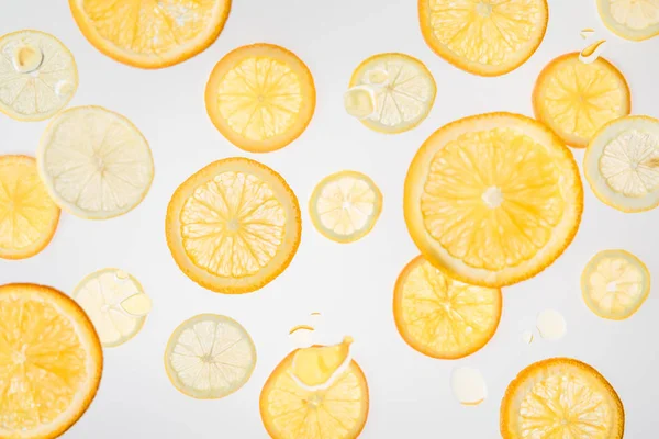 Rodajas de naranja fresca brillante y limón sobre fondo gris - foto de stock