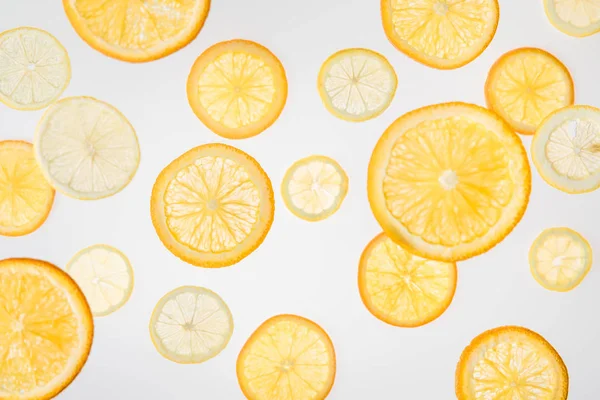 Helle Orangen- und Zitronenscheiben auf grauem Hintergrund — Stockfoto