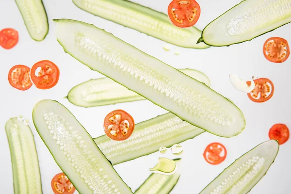 Fondo con tomates en rodajas y pepinos con burbujas de agua en gris - foto de stock