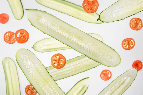 Background with sliced red tomatoes and cucumbers on grey — Stock Photo