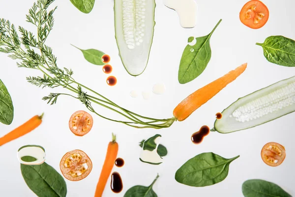 Сезонні стиглі нарізані овочі на сірому фоні з бульбашками води та краплями соусу — стокове фото
