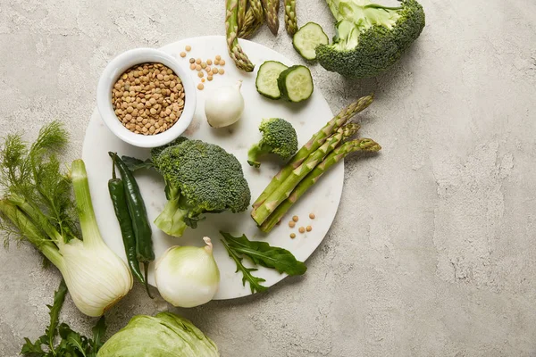 Vue du dessus des légumes et des graines sur une surface grise texturée — Photo de stock