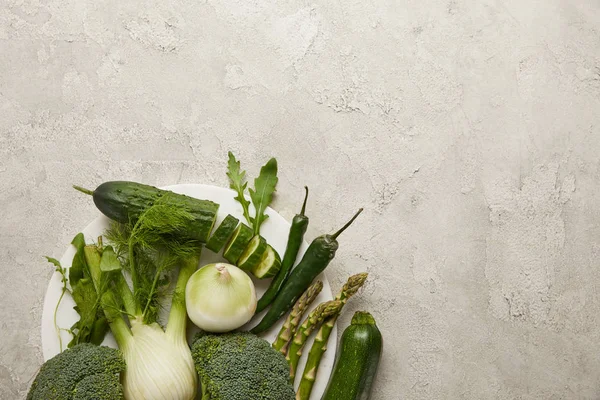 Vista superior de verduras frescas en superficie texturizada gris - foto de stock
