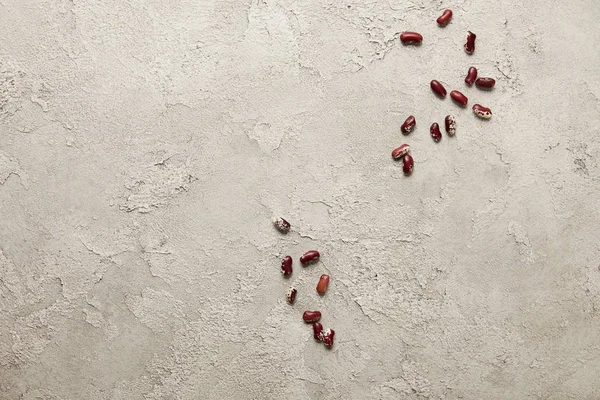 Вид зверху червоних бобів на сірій текстурованій поверхні — стокове фото