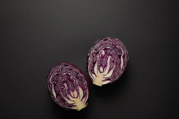 Top view of cut red cabbage on black surface — Stock Photo