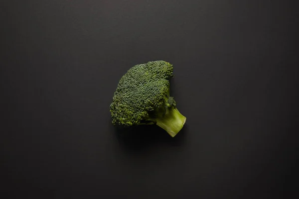 Top view of fresh green broccoli on black surface — Stock Photo