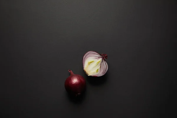Draufsicht auf frisch geschnittene Zwiebel auf schwarzer Oberfläche — Stockfoto