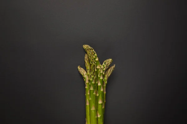 Vue de dessus des asperges vertes fraîches sur la surface noire — Photo de stock