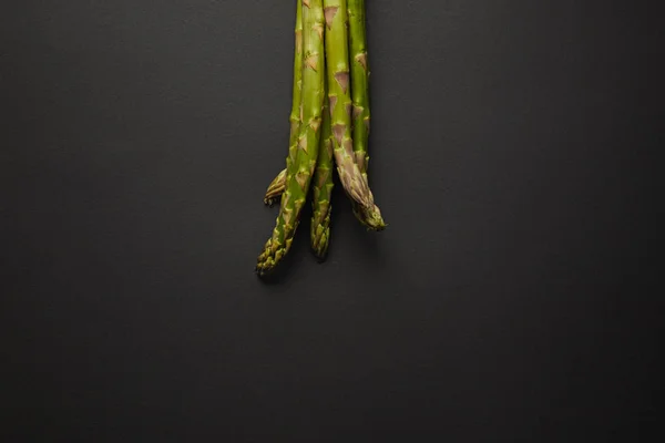 Vue de dessus des asperges vertes fraîches sur la surface noire — Photo de stock