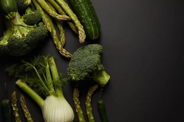 Draufsicht auf frisches grünes Gemüse auf schwarzer Oberfläche — Stockfoto