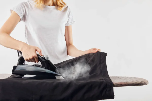 Partial view of woman with iron ironing clothes isolated on grey — Stock Photo