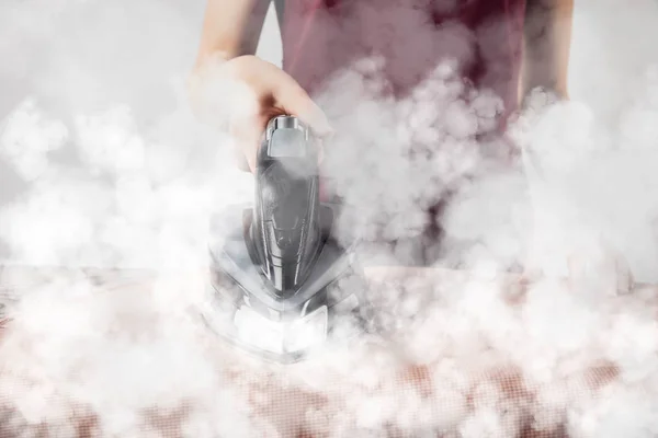 Partial view of young woman ironing clothes with iron — Stock Photo