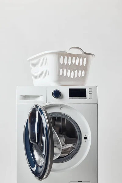 Washing machine with laundry basket isolated on grey — Stock Photo