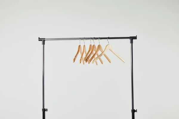 Стальная прямая стойка с деревянными вешалками, изолированными на сером — стоковое фото