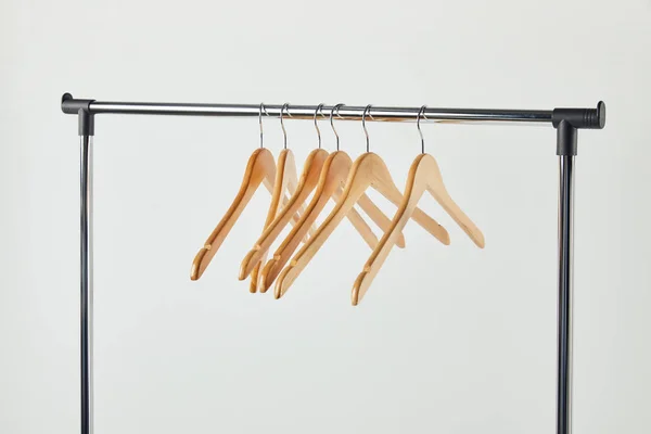 Steel straight rack with wooden hangers isolated on grey — Stock Photo