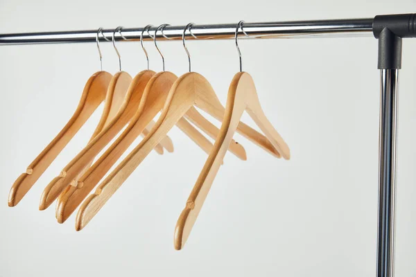 Steel straight rack with wooden hangers isolated on grey — Stock Photo