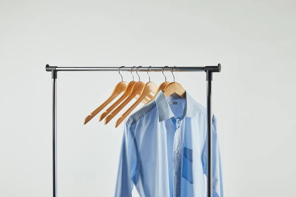 Scaffale dritto, appendini in legno e camicia blu isolata su grigio — Foto stock