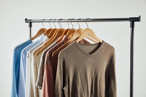 Straight rack, wooden hangers and male clothes isolated on grey — Stock Photo