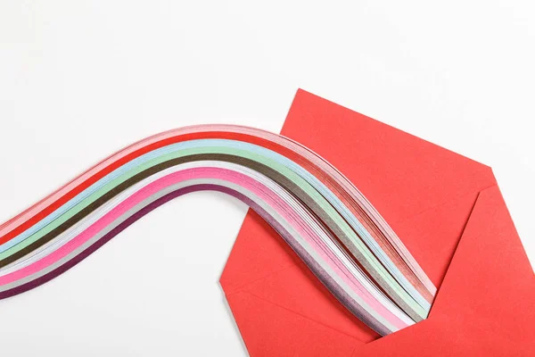 Close up of red envelope with multicolored rainbow on white background — Stock Photo