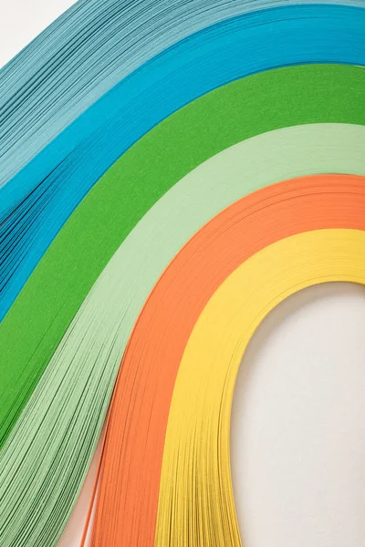 Primer plano de líneas onduladas de papel arco iris sobre fondo gris - foto de stock