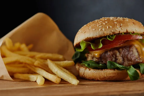 Leckere Burger mit Fleisch und Pommes frites auf Holzboden — Stockfoto