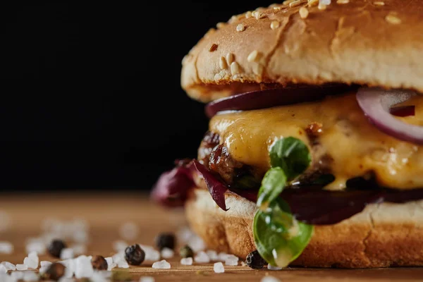 Close up de sal e delicioso hambúrguer com carne, queijo e cebola — Fotografia de Stock