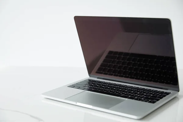 Ordinateur portable avec écran blanc et clavier noir sur surface blanche isolé sur blanc — Photo de stock