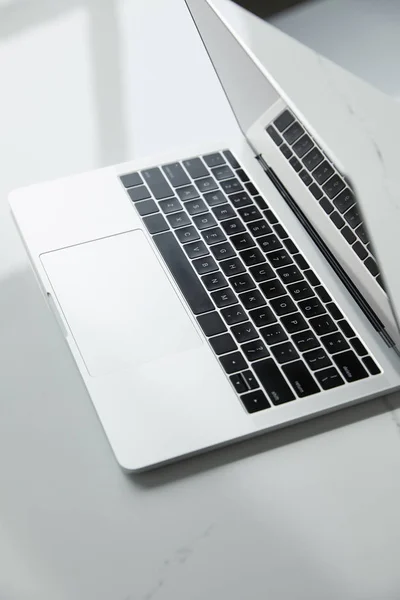 Fuoco selettivo di computer portatile con tastiera nera su tavolo bianco — Foto stock