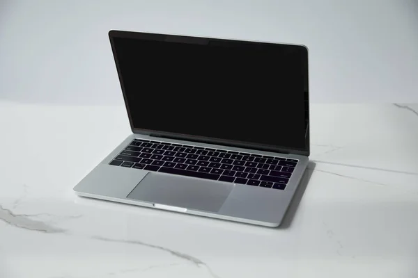 Ноутбук з порожнім екраном і чорна клавіатура на білій мармуровій поверхні ізольовані на сірому — стокове фото