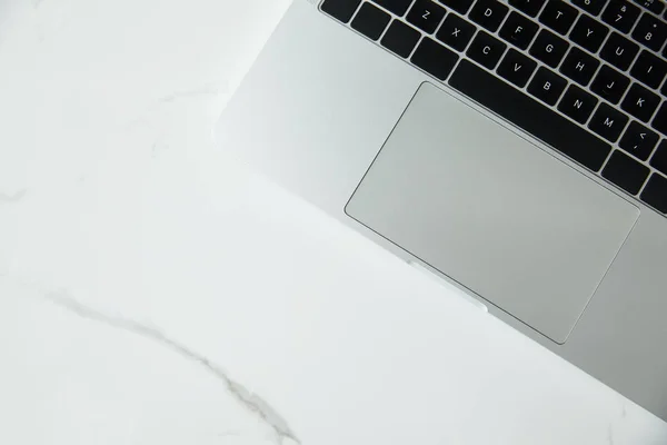 Top view of laptop with black keyboard on white marble surface — Stock Photo