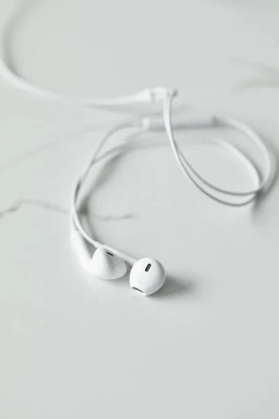 Enfoque selectivo de auriculares blancos en superficie blanca con espacio de copia - foto de stock