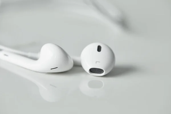 Selective focus of wired earphones on white surface with copy space — Stock Photo