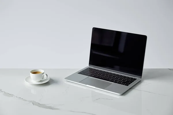 Laptop with blank screen and white coffee cup isolated on grey — Stock Photo