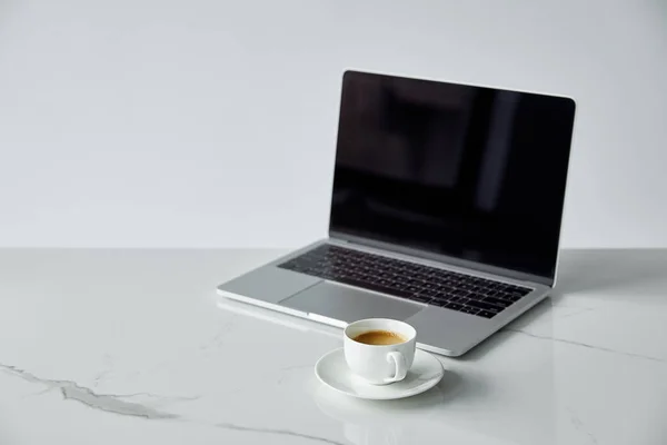 Laptop with blank screen and white coffee cup isolated on grey — Stock Photo