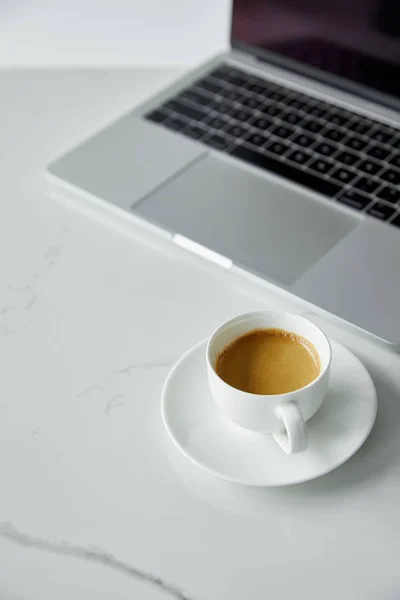 Selective focus of coffee cup wit latte and laptop with black keyboard isolated on grey — Stock Photo