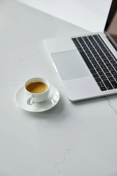 Selective focus of laptop with black keyboard and coffee cup isolated on grey — Stock Photo