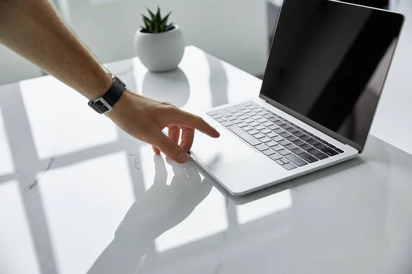 Selective focus of man touching laptop with blank screen — Stock Photo