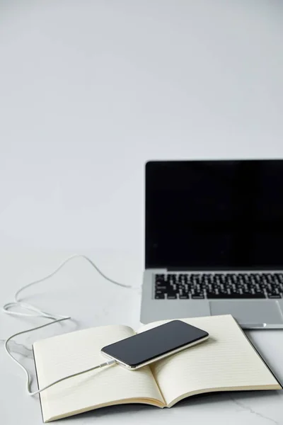 Laptop with blank screen, smartphone and notebook isolated on grey — Stock Photo