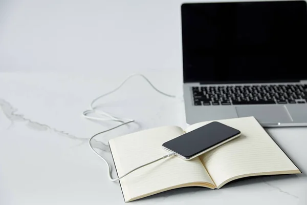 Laptop with blank screen, smartphone and notebook isolated on grey — Stock Photo