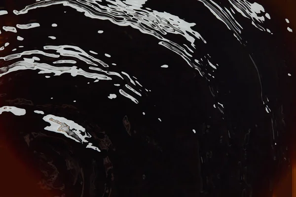 Vista de cerca del fondo oscuro con textura líquida - foto de stock