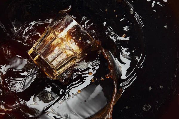 Overturned glass with black coffee, big splash and drops — Stock Photo