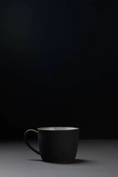 Xícara de café na superfície texturizada escura em preto — Fotografia de Stock