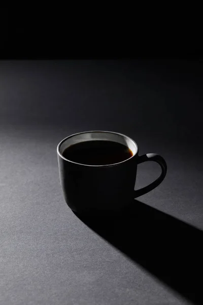Taza de café sobre superficie gris sobre negro - foto de stock